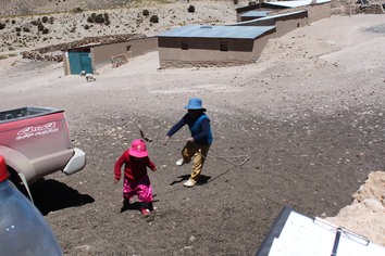 Barn som leker med lasso på Altiplano i Chile